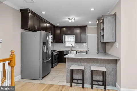 a kitchen with stainless steel appliances granite countertop a refrigerator a sink a stove a microwave and island