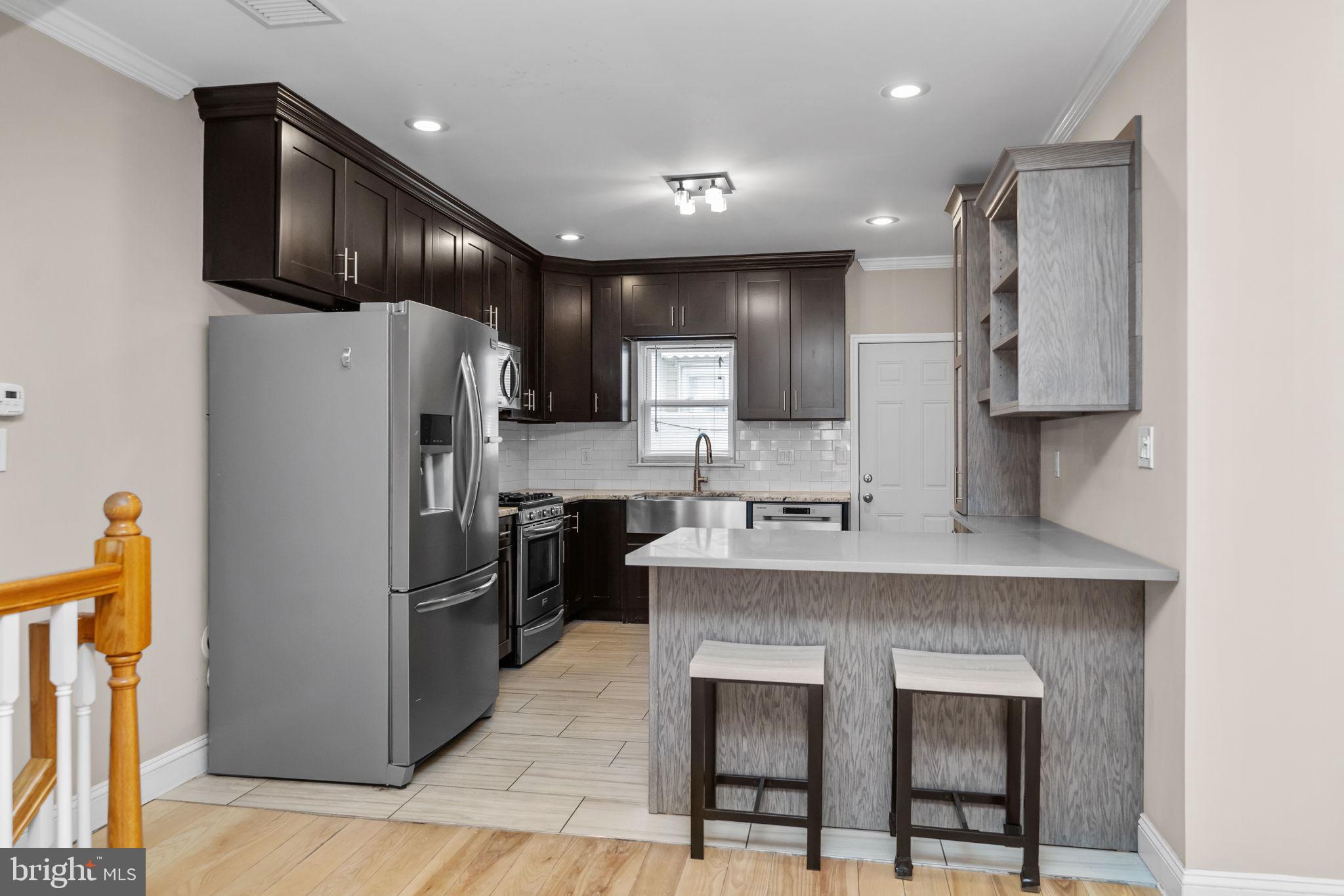 1225 South 7th Street Philadelphia, PA 19147 - Photo 8 of 33 a kitchen with stainless steel appliances granite countertop a refrigerator a sink a stove a microwave and island