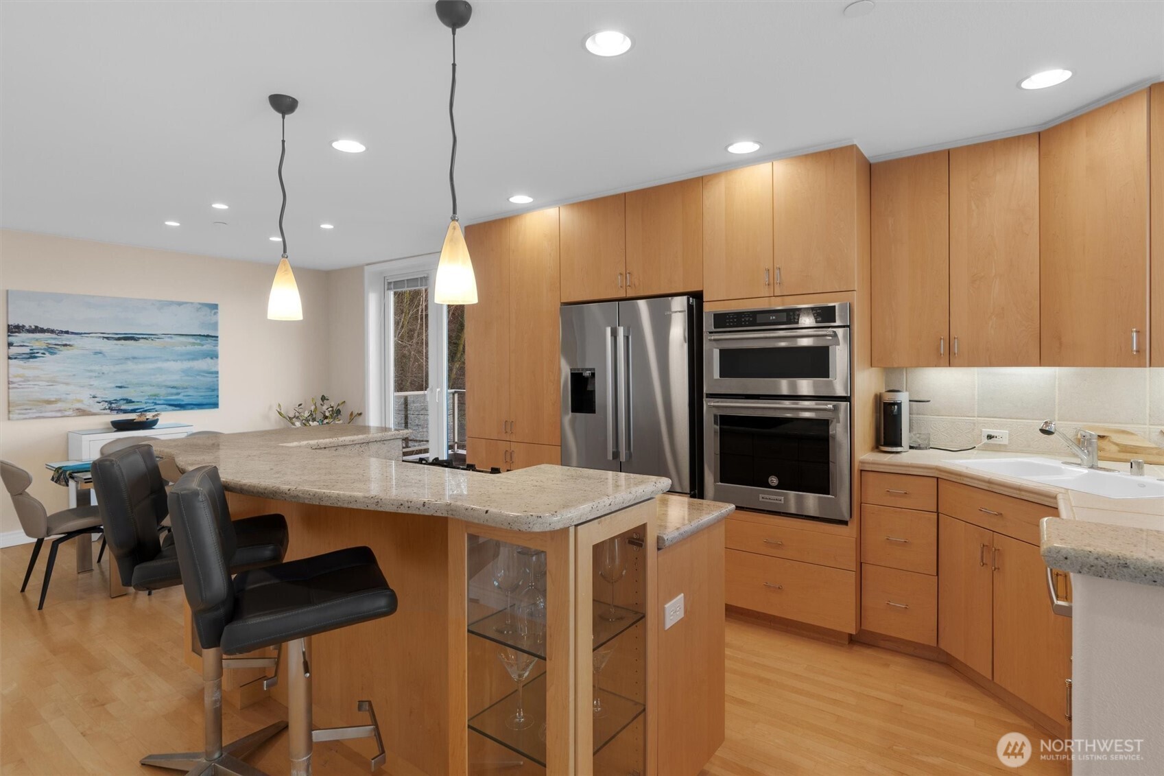 1005 Harbor Avenue Southwest, Unit 400 Seattle, WA 98116 - Photo 11 of 39 a kitchen with stainless steel appliances kitchen island granite countertop a table chairs and a refrigerator