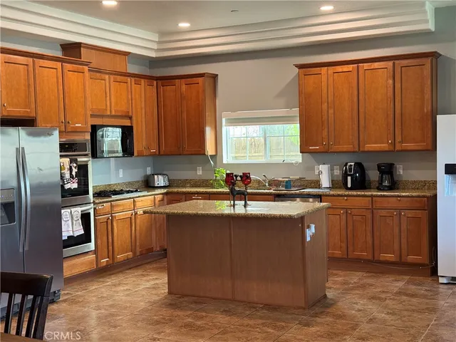 a kitchen with stainless steel appliances granite countertop a stove a sink dishwasher a refrigerator and a microwave oven