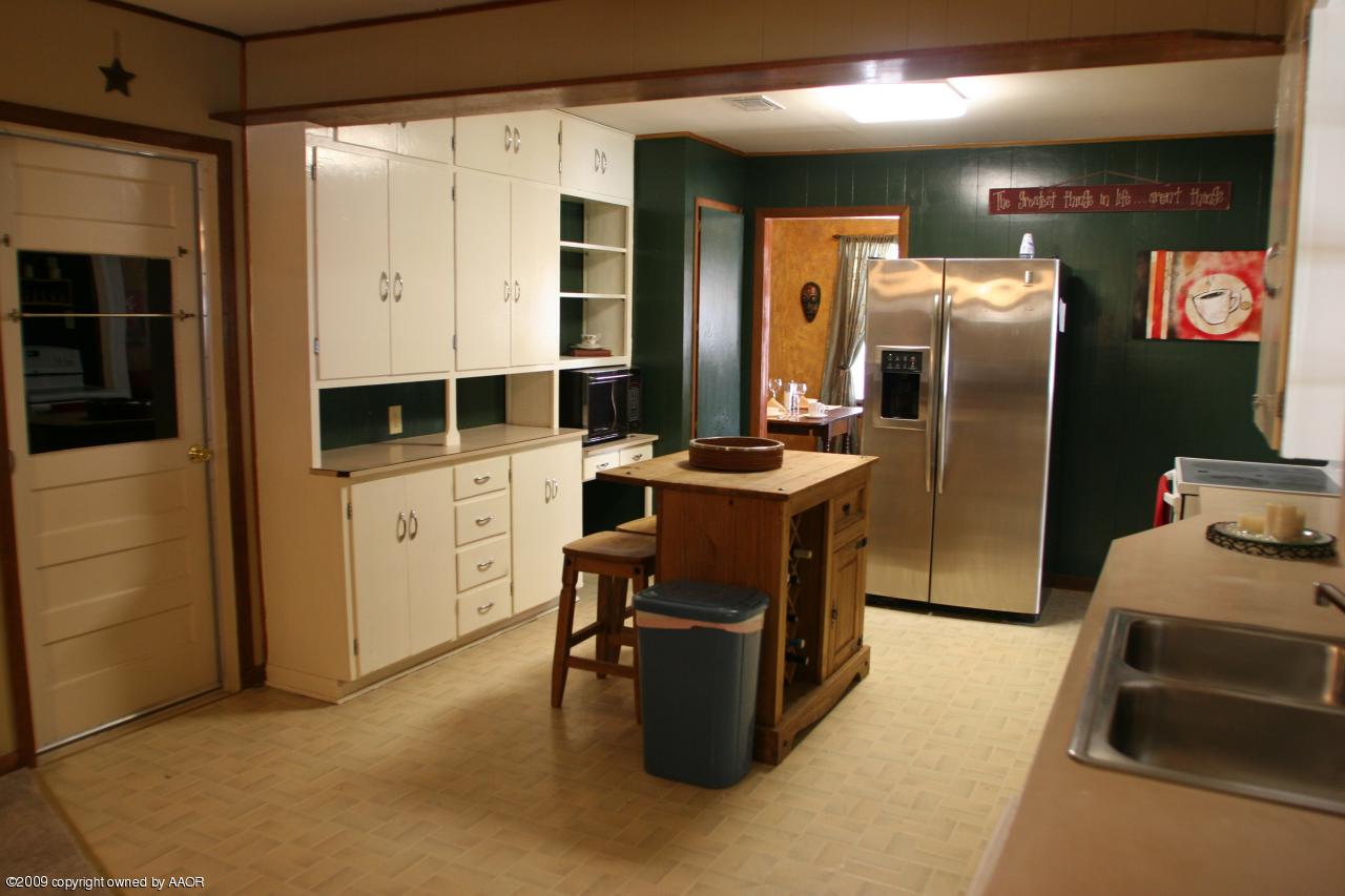 3622 South Travis Street Amarillo, TX 79110 - Photo 12 of 32 a kitchen with stainless steel appliances kitchen island granite countertop a refrigerator and a stove