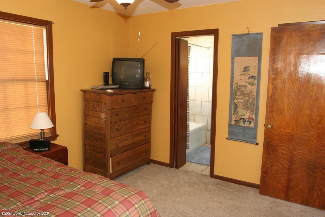 3622 South Travis Street Amarillo, TX 79110 - Photo 16 of 32 a view of a bedroom with closet and mirror