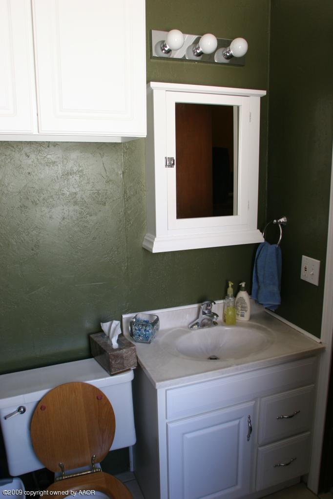 3622 South Travis Street Amarillo, TX 79110 - Photo 18 of 32 a bathroom with a toilet sink and mirror