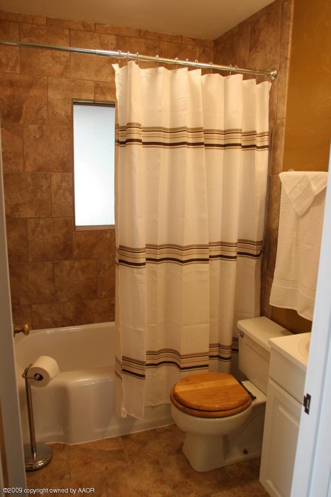 3622 South Travis Street Amarillo, TX 79110 - Photo 25 of 32 a bathroom with a toilet and a bath tub
