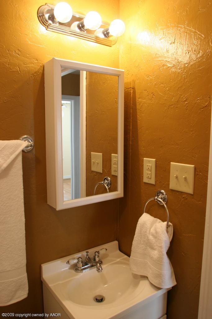 3622 South Travis Street Amarillo, TX 79110 - Photo 26 of 32 a bathroom with a sink and mirror with toilet