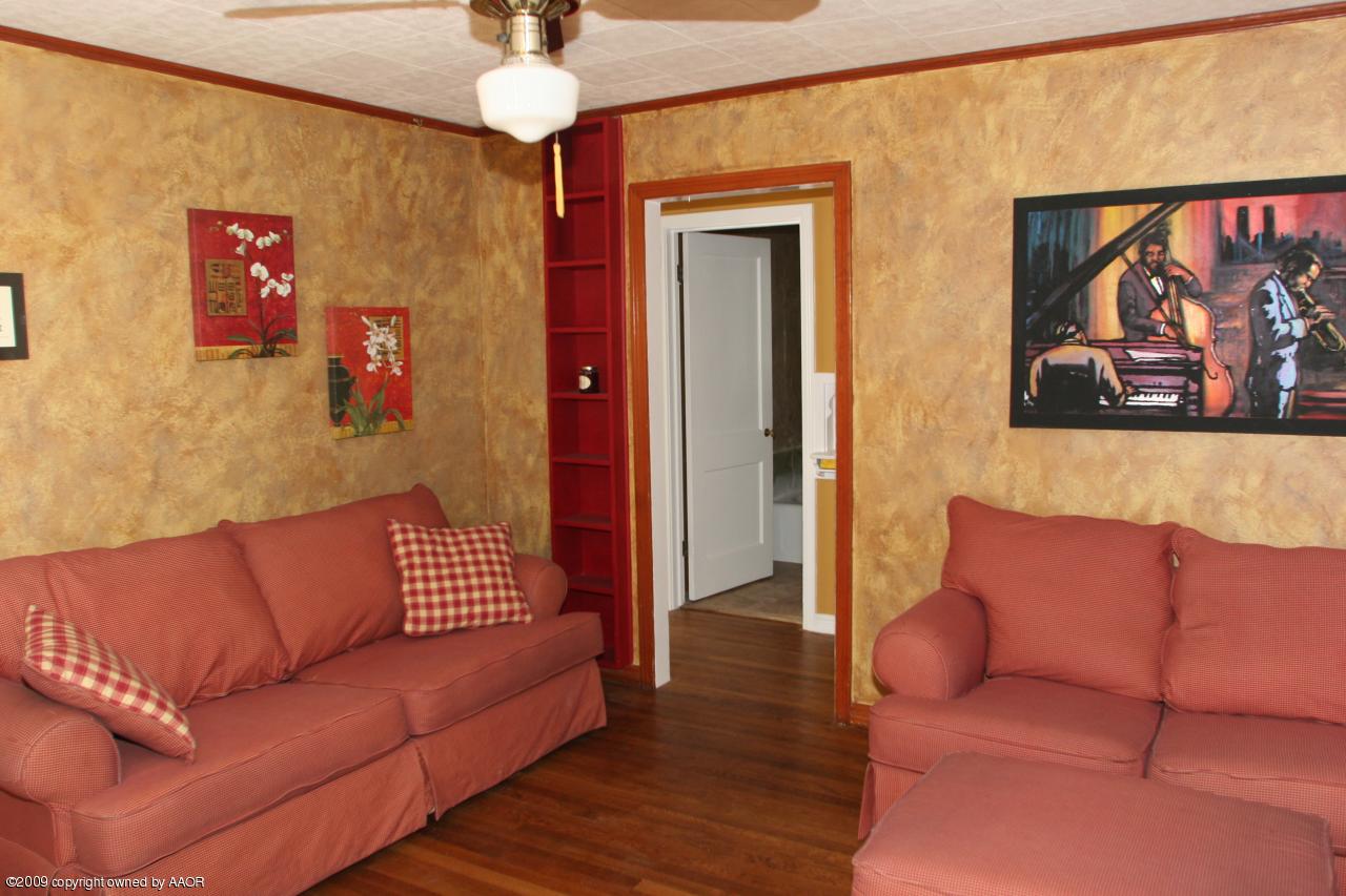 3622 South Travis Street Amarillo, TX 79110 - Photo 5 of 32 a blue couch sitting in a living room with a rug and a painting on the wall