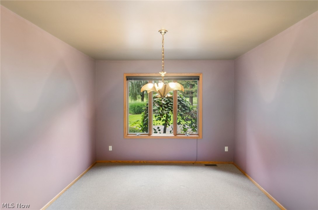 200 Hampshire Road Akron, OH 44313 - Photo 20 of 50 Recessed window with wood-finish trim, suspended chandelier, and neutral carpeting