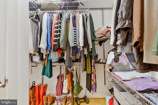a view of walk in closet with clothes