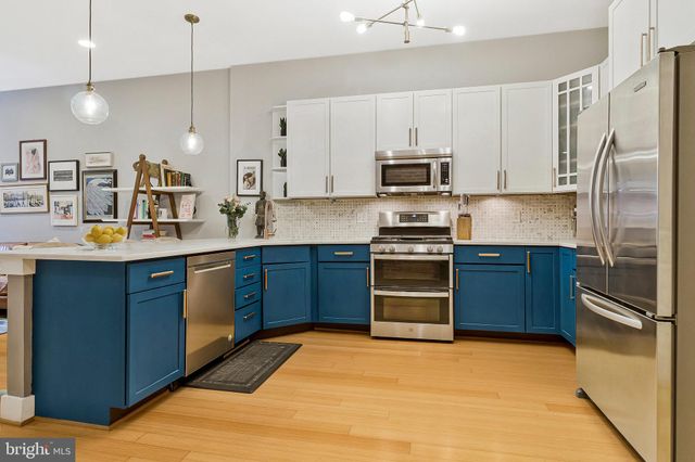 a kitchen with stainless steel appliances granite countertop a refrigerator stove and sink