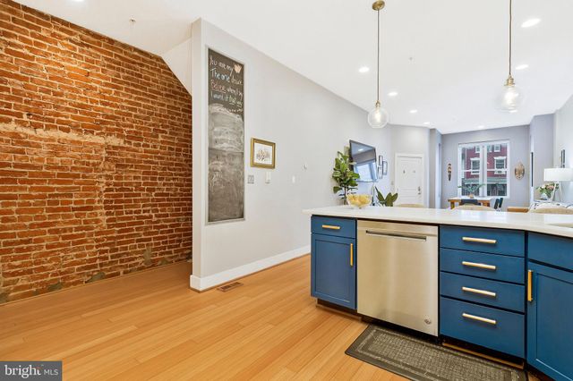 a kitchen with stainless steel appliances granite countertop a sink cabinets and wooden floor