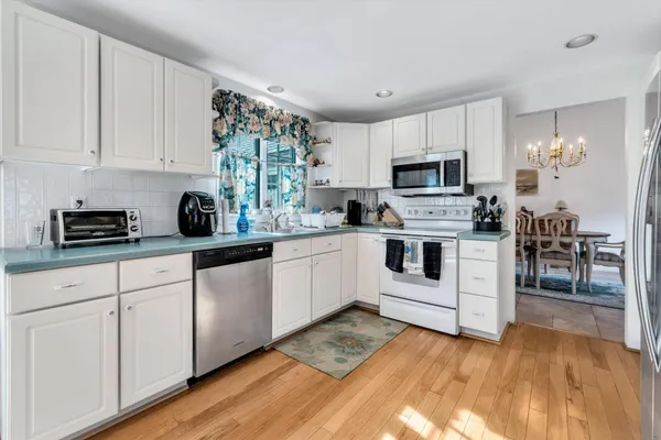 a kitchen with white cabinets and white appliances