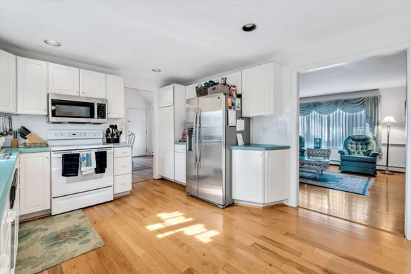 a kitchen with granite countertop a refrigerator a stove top oven a sink and dishwasher