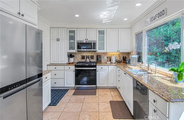 a kitchen with stainless steel appliances granite countertop a refrigerator and a stove top oven