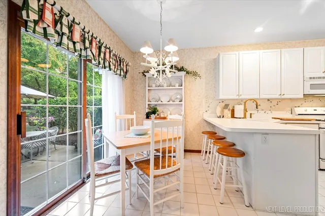 a view of a dining room with furniture a chandelier and large windows