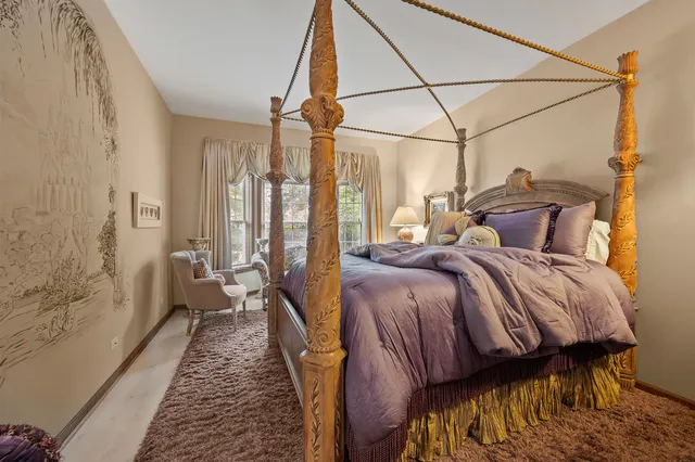 a bedroom with a bed next to a window