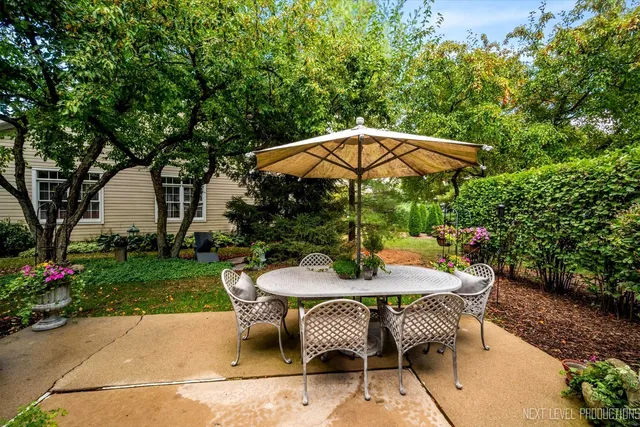 a patio with a table and chairs under an umbrella