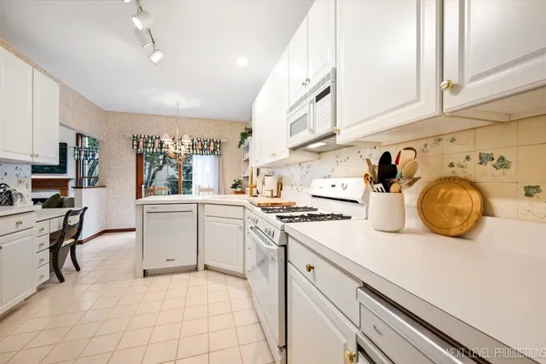 a kitchen with granite countertop a sink a stove and cabinets