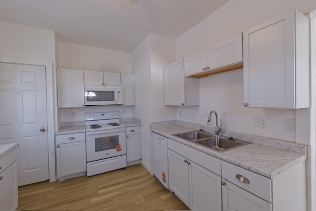 721 South 6th Street Clinton, IA 52732 - Photo 6 of 25 a kitchen with sink cabinets and wooden floor