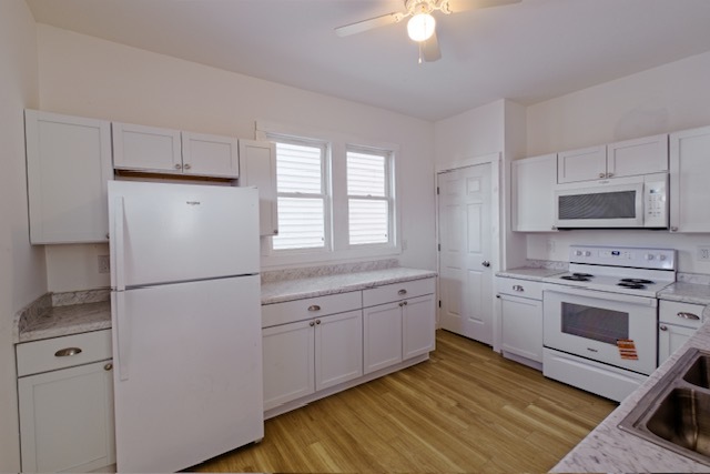 721 South 6th Street Clinton, IA 52732 - Photo 7 of 25 a kitchen with white cabinets and white appliances
