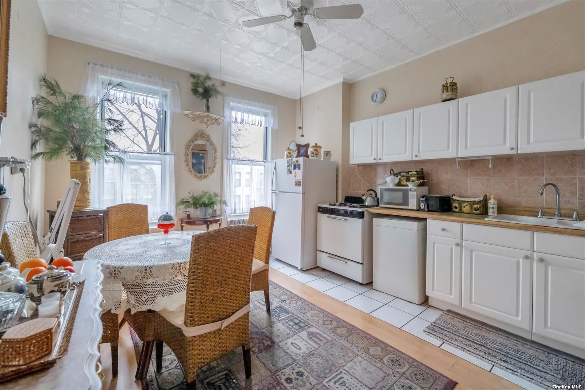 32 Sutton Street Brooklyn, NY 11222 - Photo 18 of 35 a kitchen with stainless steel appliances granite countertop a dining table chairs refrigerator and sink