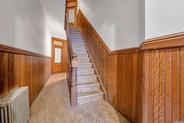 a view of staircase with railing and white walls
