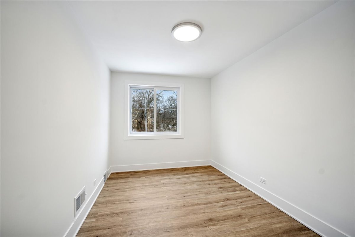 803 Brummel Street Evanston, IL 60202 - Photo 15 of 21 an empty room with wooden floor and windows