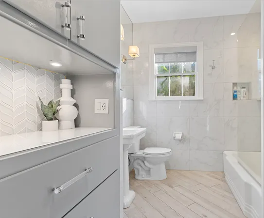 a bathroom with a sink a toilet and a large mirror