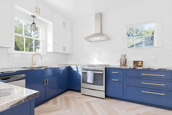 a kitchen with stainless steel appliances granite countertop a sink and a stove