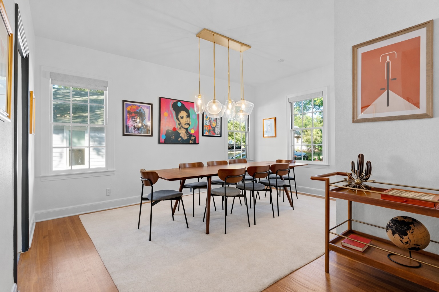 2106 Eva Street Austin, TX 78704 - Photo 8 of 13 a dining room with wooden floor a chandelier a wooden table and chairs