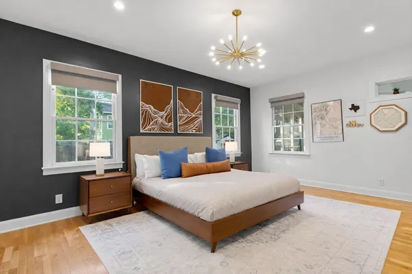 a bedroom with a large bed and a chandelier