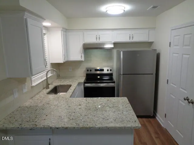 a kitchen with granite countertop a refrigerator and a stove