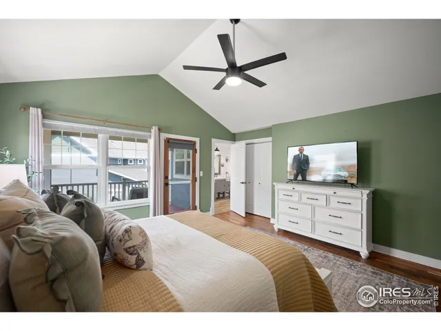 a bedroom with a bed a window and a flat screen tv