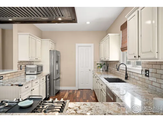 a kitchen with stainless steel appliances kitchen island granite countertop a stove a sink and a microwave