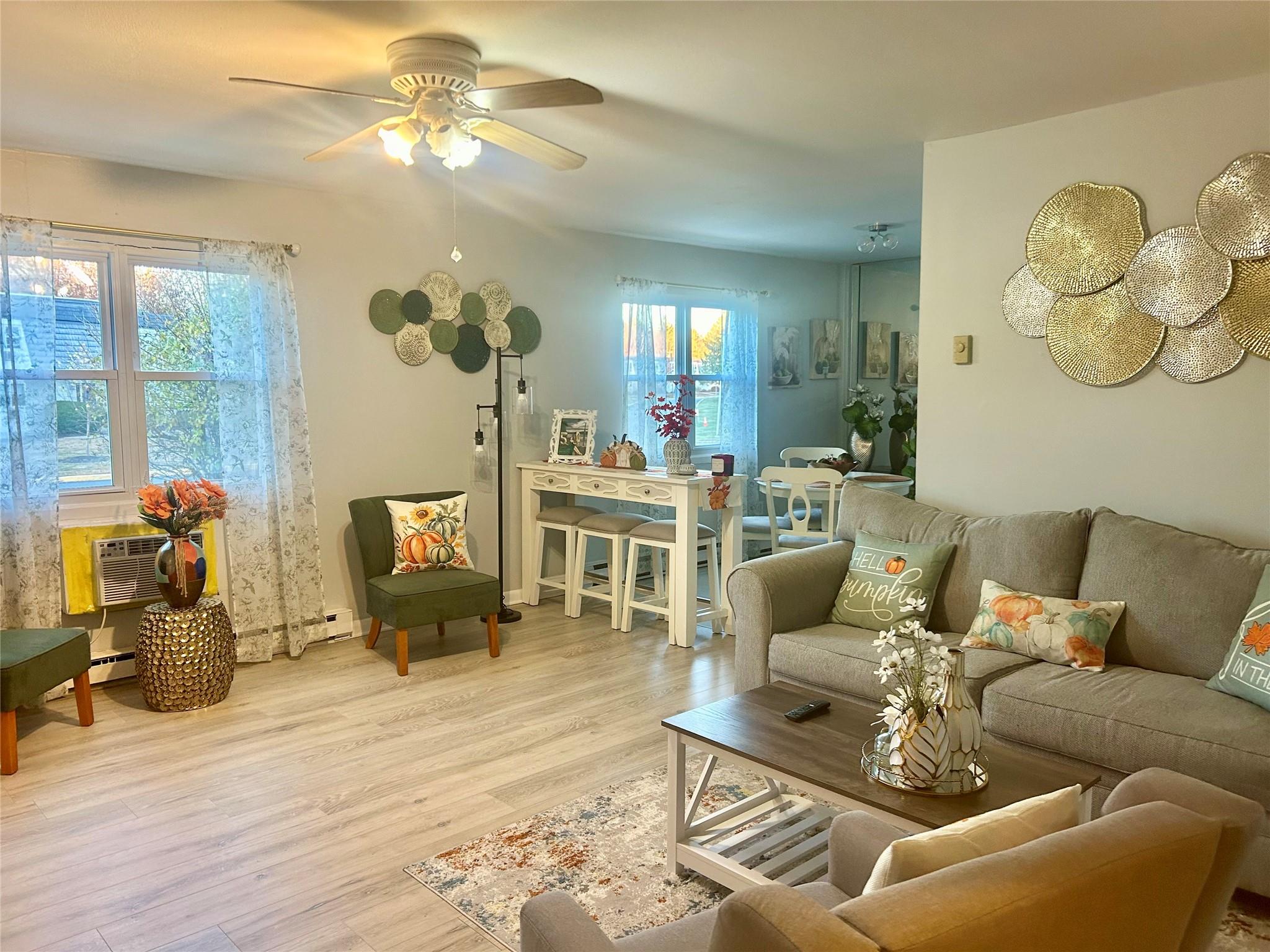 a living room with furniture a chandelier fan and a fireplace