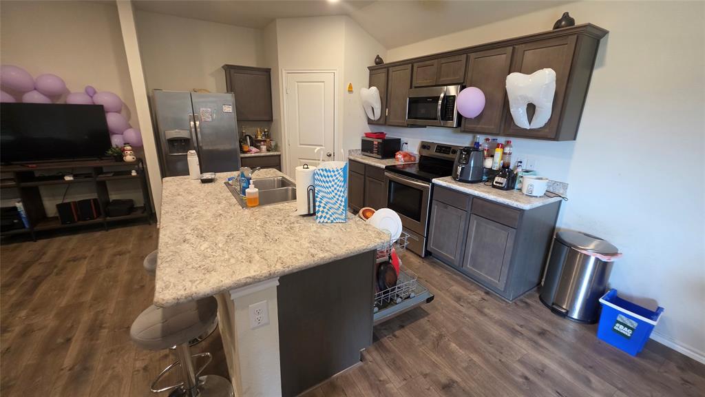 409 Samuel Street Denton, TX 76207 - Photo 21 of 40 a kitchen with stainless steel appliances granite countertop a sink dishwasher and a flat screen tv