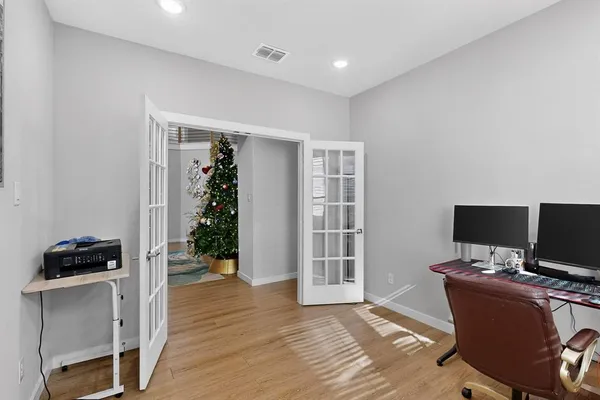 an empty room with windows and ceiling fan
