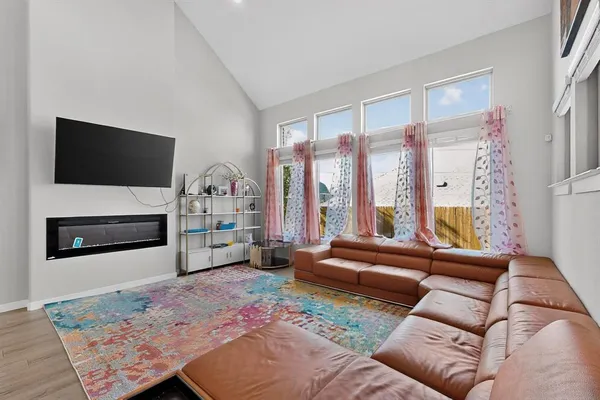 a living room with furniture a flat screen tv and a fireplace