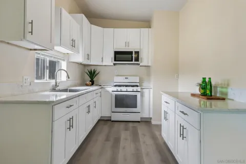 a kitchen with white cabinets and white appliances