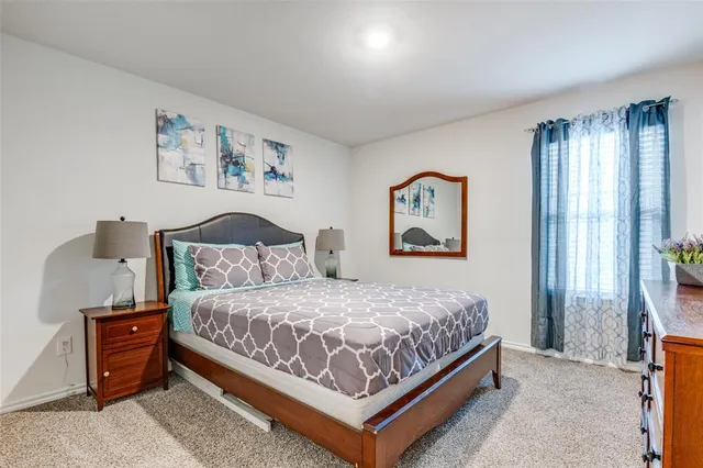 a bedroom with a bed and a painting on the wall