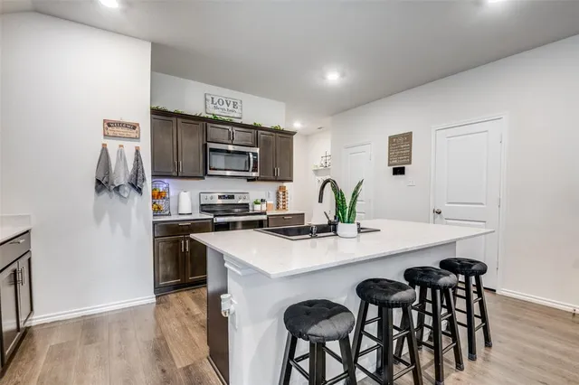 a kitchen with stainless steel appliances a sink and a refrigerator
