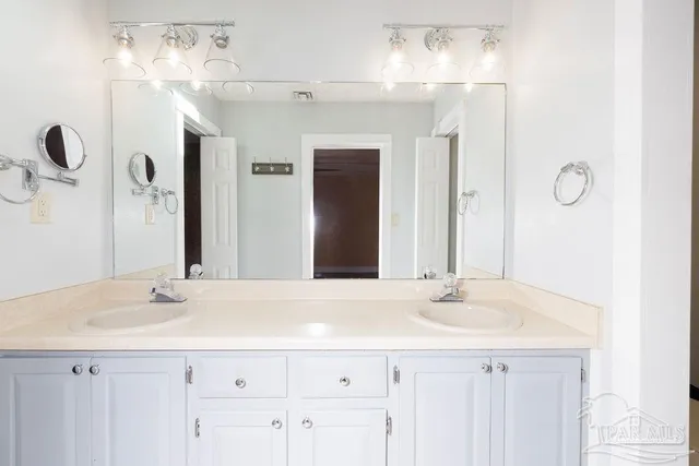 a bathroom with a sink vanity and a mirror