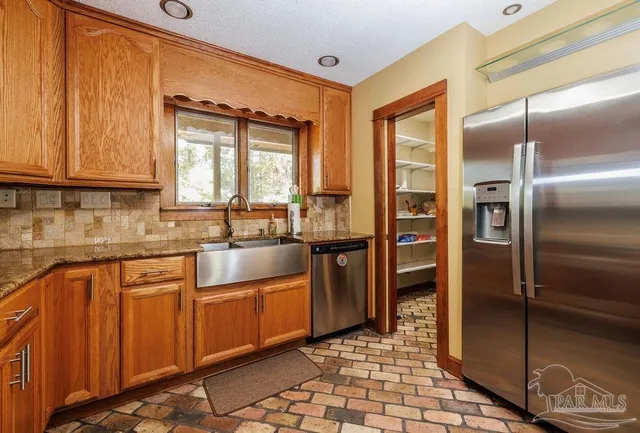 a kitchen with stainless steel appliances granite countertop a refrigerator and a sink