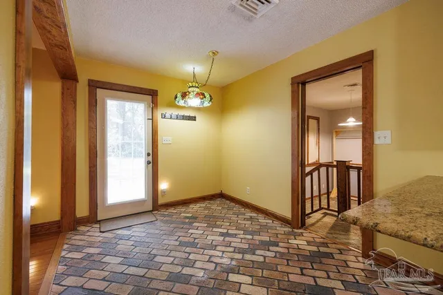 a view of a livingroom with wooden floor and a bathroom