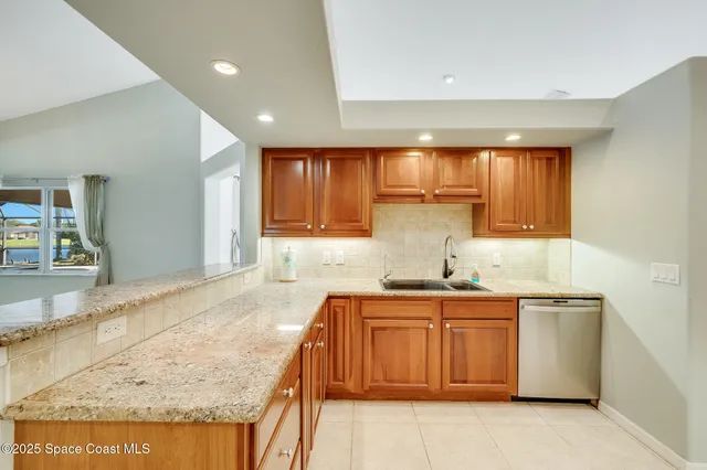 a kitchen with granite countertop a sink stove cabinets and refrigerator
