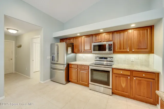 a view of a kitchen with wooden floor and a window