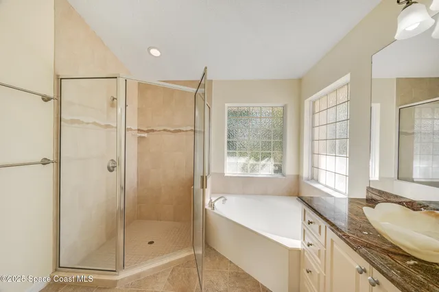 a bathroom with a tub sink shower and mirror