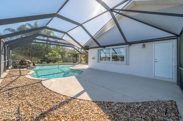 a view of backyard with a table and chairs under an umbrella