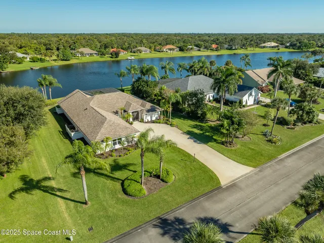 an aerial view of residential houses with outdoor space and lakeside
