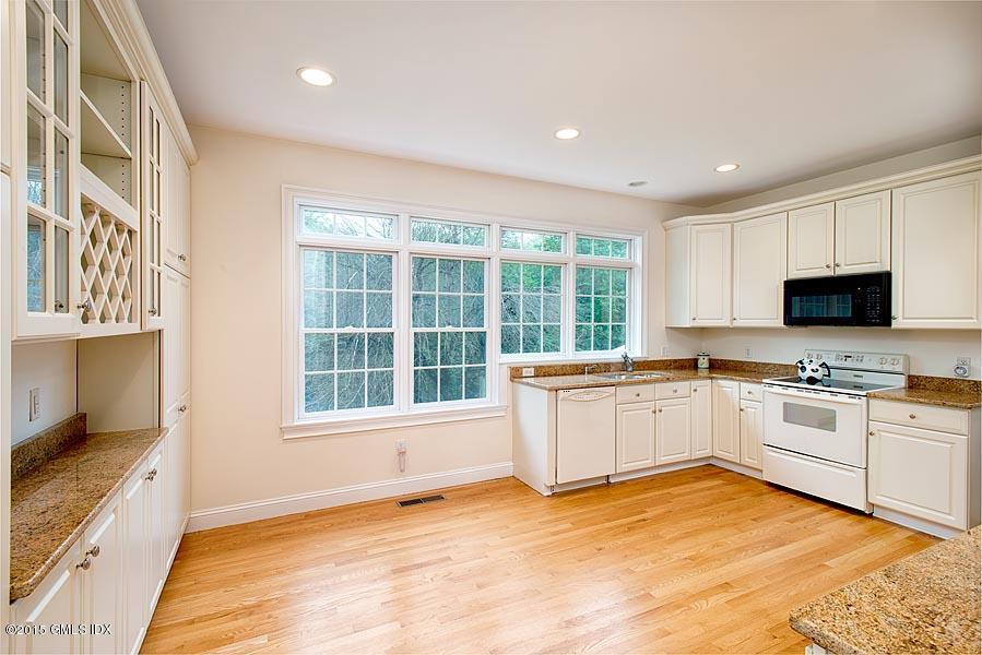 108 Cutler Road Greenwich, CT 06831 - Photo 4 of 15 a large white kitchen with granite countertop a stove a sink a window and white stainless steel appliances