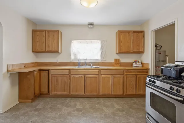 a kitchen with granite countertop a sink cabinets and stainless steel appliances
